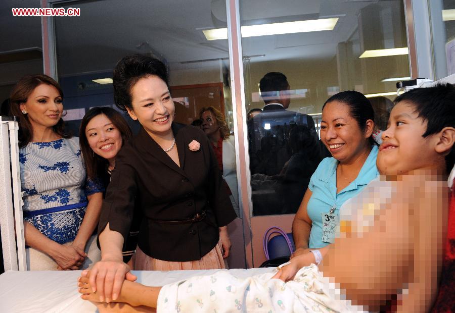 Peng Liyuan (3rd L), wife of Chinese President Xi Jinping, accompanied by Mexico's first lady Angelica Rivera, comforts a child patient during her visit to Federico Gomez Children's Hospital, in Mexico City, Mexico, June 4, 2013. (Xinhua/Rao Aimin) 