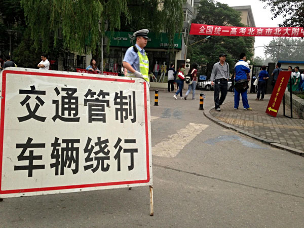 A traffic control sign is placed near an exam site in Beijing, June 7, 2013. The 2013 national college entrance examination kicked off on Friday, with 9.12 million students. [Photo/Xinhua]
