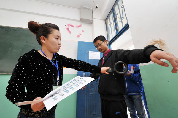 A student is inspected before taking the college entrance examination in Xiji county, Northwest China's Ningxia Hui autonomous region, June 7, 2013. [Photo/Xinhua]