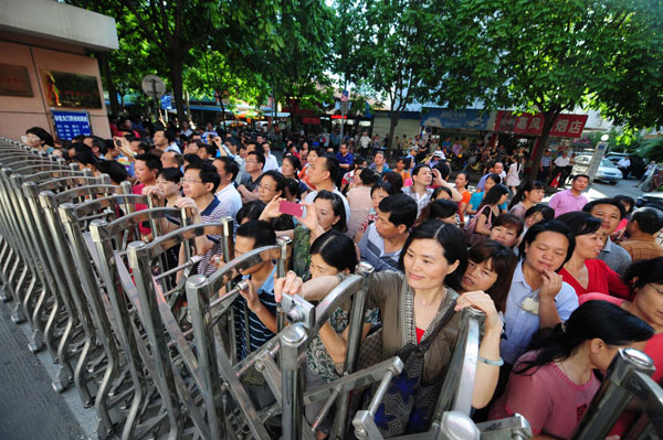 Parents wait outside a test site on the first day of the college entrance examination, in Nanning, South China's Guangxi Zhuang autonomous region, June 7, 2013.  [Photo/Xinhua]