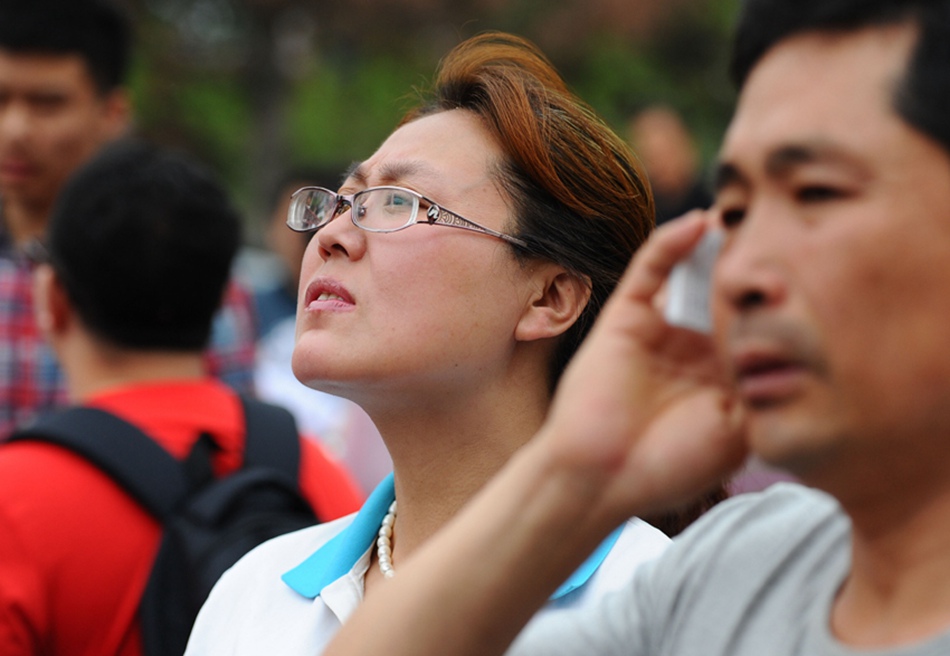 Parents wait outside an examination site in Changchu, Jilin Province, on June 7. Some 9.12 million applicants are expected to sit this year's college entrance exam, down from 9.15 million in 2012, a spokeswoman for the Ministry of Education (MOE) said on Wednesday. [Photo/Xinhua]