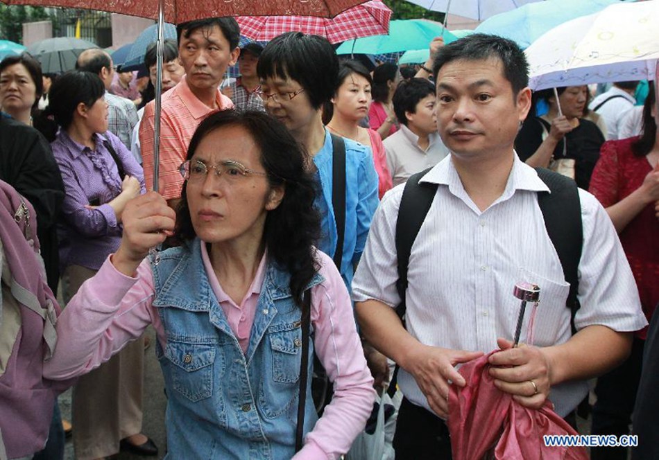 Parents watch their children entering the exam site to take the national college entrance exam in Shanghai, east China, June 7, 2013. Some 9.12 million applicants are expected to sit this year's college entrance exam.