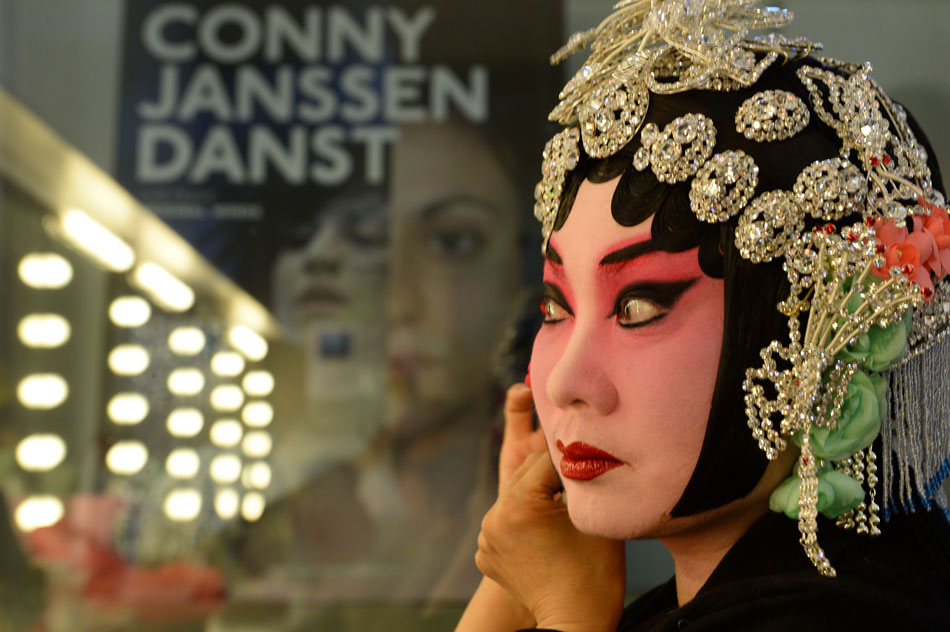 Wang Rongrong, well known Peking Opera actoress, puts on makeup before performance in Nederlands Dans Theater in Hague, the Netherlands on May 23, 2013.  (Photo/Xinhua)