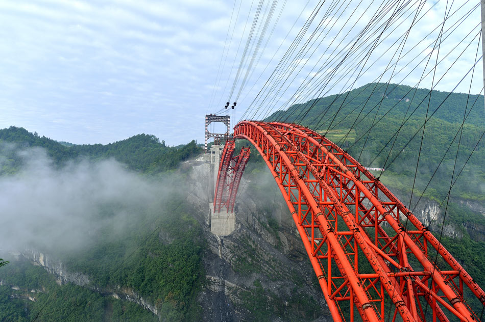 Photo taken on June 2, 2013 shows that the steel arch of Longqiaote Bridge in Enshi of central China's Hubei province is going to be joined. (Xinhua/Song Wen)