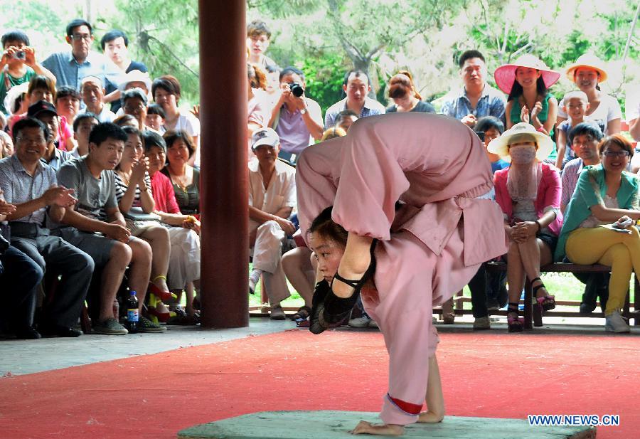 A girl performs acrobatics on the Cultral Week for the annual Dragon Boat Festival in Kaifeng, central China's Henan Province, June 9, 2013. The week-long event, which was kicked off here Sunday, will held a series of activities of folk custom, showcasing local intangible cultural heritage to tourists. (Xinhua/Wang Song)