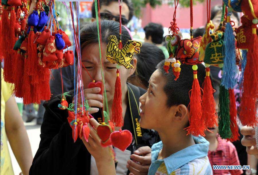 Citizens visit a cultural festival during the Dragon Boat (Duanwu) Festival holiday in Yanqing County of Beijing, capital of China, June 10, 2013. The Duanwu Festival, which is celebrated across China to pay homage to Qu Yuan, a patriotic poet during the Warring State Period (475-221 BC), falls on the fifth day of the fifth month in the Chinese lunar calendar, or June 12 this year. (Xinhua/Li Xin)