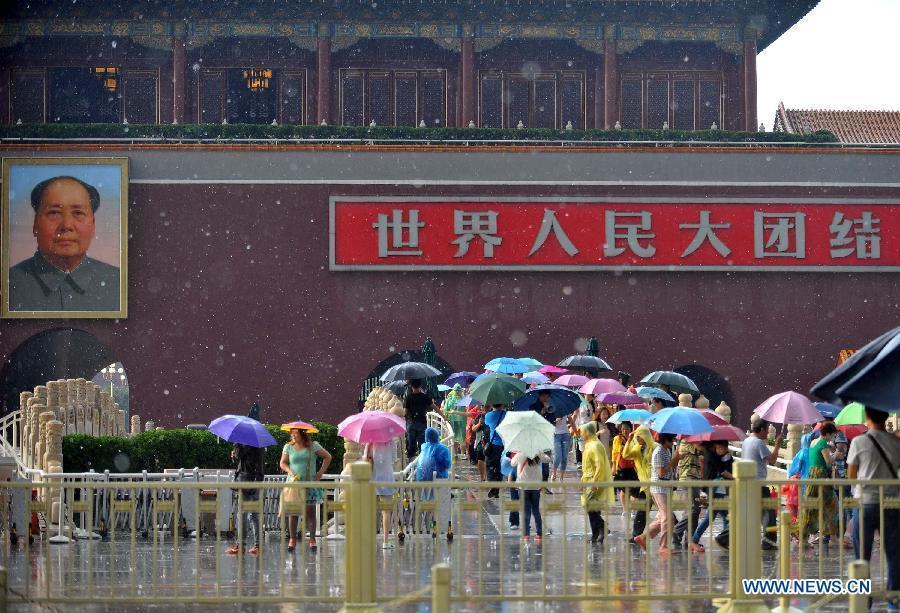 Visitors walk past the Tian'anmen Rostrum in rain and hail in Beijing, capital of Beijing, June 11, 2013. (Xinhua/Chen Yehua)