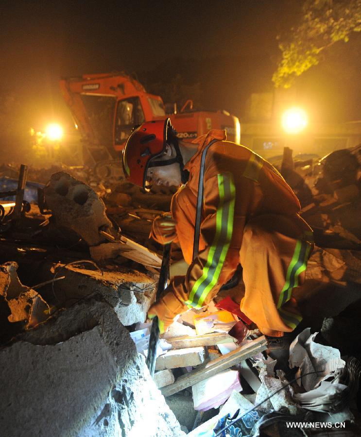 A rescuer looks for victims at the accident site after an explosion toppled a three-story building in Suzhou City, east China's Jiangsu Province, June 11, 2013. Twenty people who were buried following an explosion of the staff canteen had been found. Eleven of them died in hospital, while the remaining nine are still receiving treatment in two local hospitals, according to the press briefing. A preliminary investigation showed that the blast was caused by a gas leak. (Xinhua/Shen Peng)