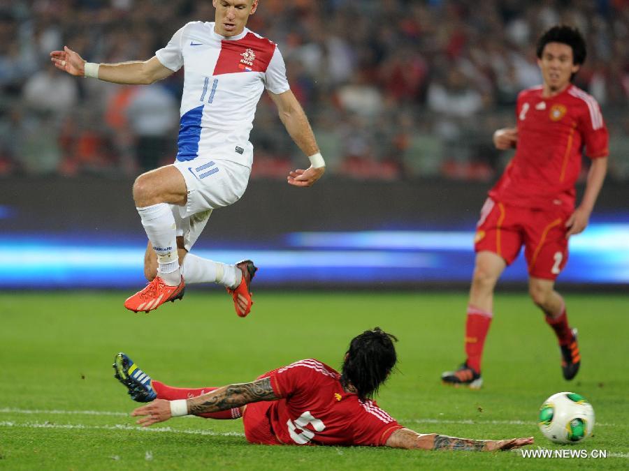 Arjen Robben (Top) of the Netherlands vies with China's Zhang Linpeng during their international friendly soccer match at the Workers Stadium in Beijing, capital of China, June 11, 2013. (Xinhua/Gong Lei)