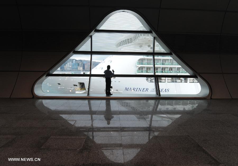 A visitor takes photos of cruise liner Mariner of the Seas through windows at the Kai Tak Cruise Terminal in Hong Kong, south China, June 13, 2013. The new cruise terminal, built at the end of the runway of the former Kai Tak Airport, received its first liner, Mariner of the Seas on June 12, which has a capacity of 3,807 people. (Xinhua/Lui Siu Wai)