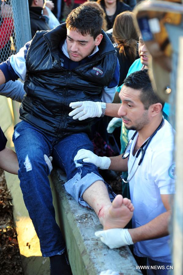 An injured passenger receives medical treatment at the scene of a commuter train crash in Castelar, some 30 kms west of Buenos Aires, capital of Argentina, on June 13, 2013. At least three people died and 135 others injured, including five in critical conditions, on Thursday in a train collision about 30 km west of the Argentine capital, local media reported. (Xinhua/Martin Zabala) 