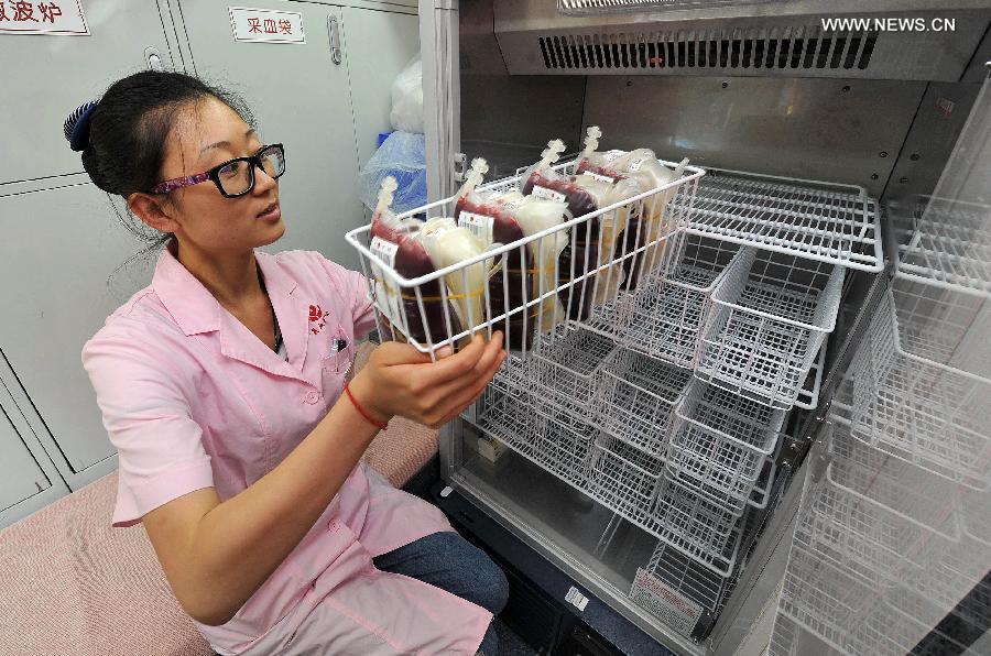 A medical staff member puts the donated blood into a storage in a voluntary blood donation house in Yinchuan, capital of Ningxia Hui Autonomous Region, June 14, 2013. June 14 is the World Blood Donor Day. Many citizens in Yinchuan donated their blood for free on the streets of Yinchuan on Friday. (Xinhua/Peng Zhaozhi)