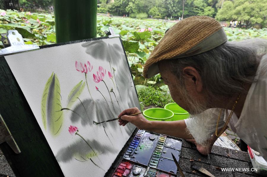 A painter draws picture of lotus flower at the Taipei Botanical Garden in Taipei, southeast China's Taiwan, June 15, 2013. (Xinhua/Wu Ching-teng) 