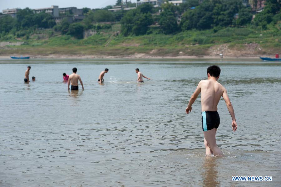 People cool themselves off in the Jialingjiang River at Ciqikou Town in Chongqing, southwest China's municipality, June 16, 2013. Local meteorological authorities issued an orange-coded alert of heat on Sunday, which indicates the temperature will rise up to 37 degrees Celsius Sunday afternoon. (Xinhua/Liu Chan)