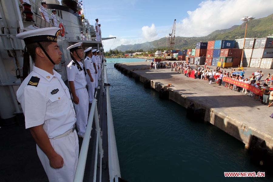 Local residents welcome the missile destroyer "Harbin" of the 14th Escort Taskforce of the Chinese Navy on Victoria Harbour, Seychelles, June 16, 2013. 65 soldiers of the 14th Escort Taskforce of the Chinese Navy will participate in the National Day Parade of Seychelles on June 18. (Xinhua/Rao Rao)