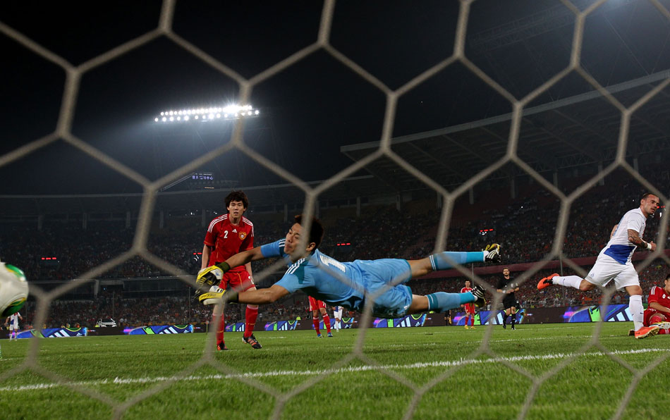 Chinese goalkeeper Zeng Ceng dives to his left to save a ball in a friendly soccer match between China and the Netherlands, which ended up with China’s loss to the Netherlands 1:3, Beijing, June 11, 2013. (Xinhua/Li Ming)