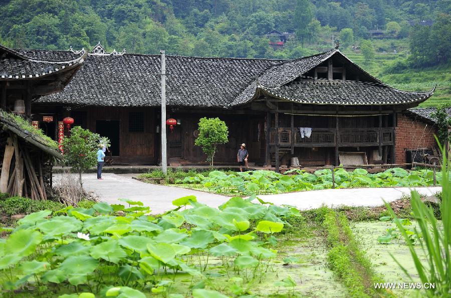 Two villagers stand in front of a wooden Diaojiaolou, or stilted house founded in the Qing Dynasty in Shiyanping Village, Wangjiaping Township of Zhangjiajie City in central China's Hunan Province. The Shiyanping Village, located in the southeast of Wangjiaping, is one of the regions in Hunan where stilted houses are well preserved. With a toal of 182 existing stilted houses of the Tujia ethnic group, the village was listed as the seventh batch of important heritage sites under state protection in 2013. (Xinhua/Shao Ying)