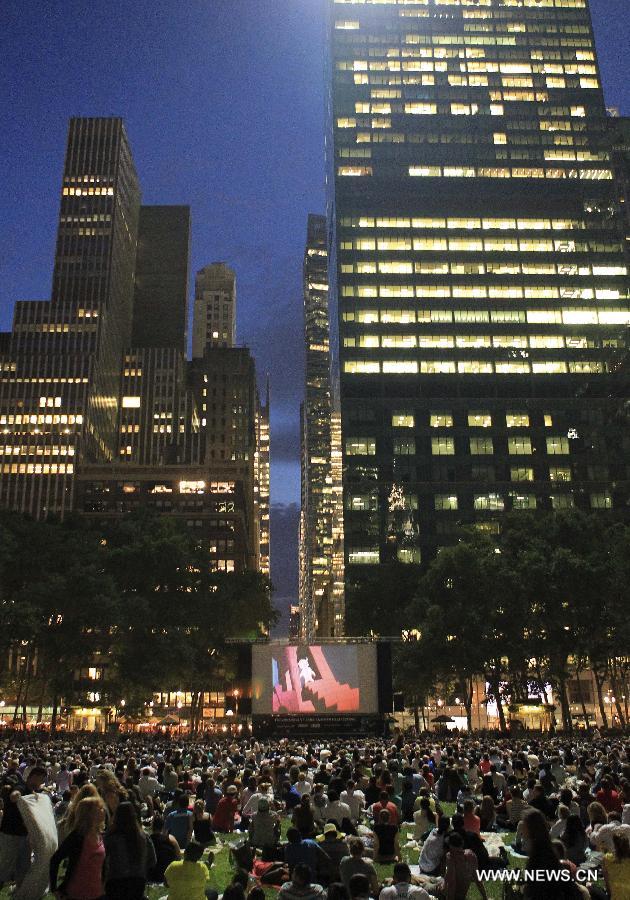 People watch a free outdoor film at Bryant Park in New York, the United States, June 17, 2013. There is a series of free outdoor films screening at Bryant Park every Monday from June 17 to August 19. (Xinhua/Cheng Li)