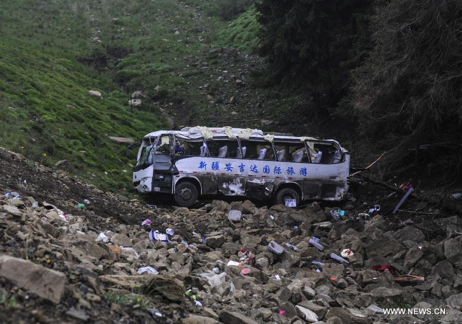 Photo taken on June 18, 2013 shows the tourist bus of the road accident in Changji City, northwest China's Xinjiang Uygur Autonomous Region. The death toll has risen to 15 in an accident in which a tourist bus fell into a valley on Tuesday in Changji, according to the local government. Four people died at the scene, while another 11 people died after hospital treatments failed. The other 21 passengers sustained injuries and are still being treated. Heavy fog that reduced visibility has been blamed for the accident. (Xinhua)