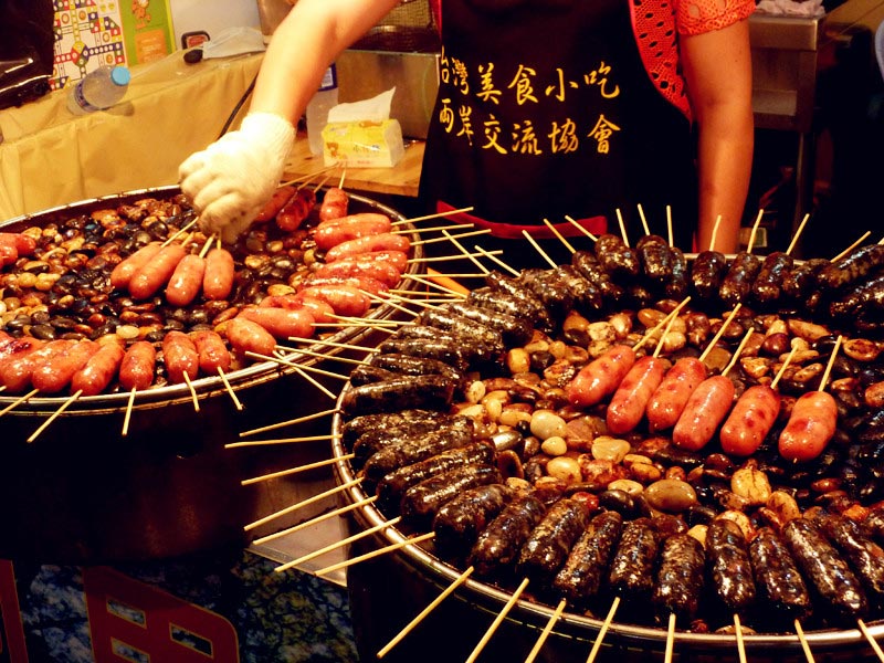 Sausage grilled on heated cobblestones is one of the most popular and typical Taiwanese snacks at the Taiwan Characteristics Temple Fair in Xiamen, southeast China's Fujian Province, on Friday, June 14, 2013. The temple fair is part of the city's fifth Straits Forum to be held on June 15-21. Vendors are selling food, specialties and creative products from Taiwan at the temple fair. (CRIENGLISH.com/Yang Yong)