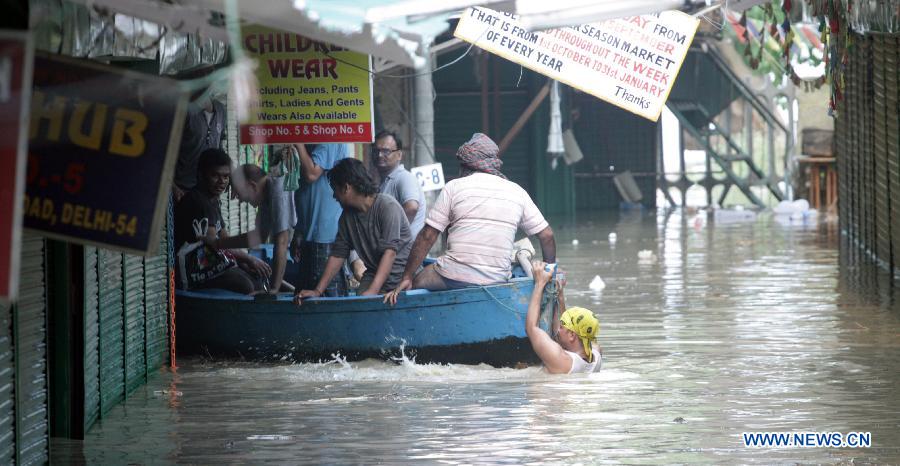 People ride boat to higher ground after floodwaters inundated homes along the banks of the Yamuna River in New Delhi, India, June 19, 2013. The Indian capital has been put on flood alert after its main Yamuna river breached the danger mark following incessant rainfall since June 16. (Xinhua/Partha Sarkar) 