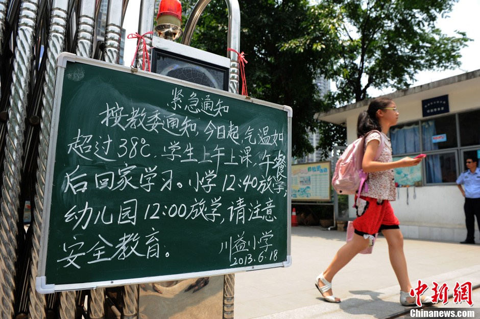 A notice at the gate of a school in Chongqing tells the students to study at home in the afternoon because of the hot weather on June 16, 2013. The temperature in Chongqing reached 38 degrees Celsius on the day. (Photo/Chinanews)