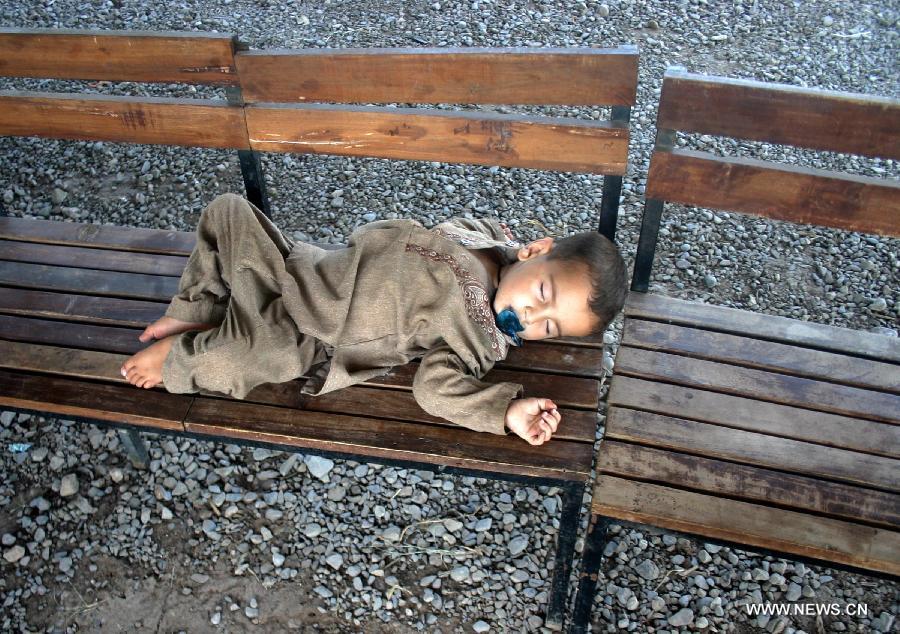An Afghan refugee boy sleeps on a bench at the office of the United Nations High Commissioner for Refugees (UNHCR) registration center before returning to Afghanistan in northwest Pakistan's Peshawar, on June 20, 2013. Some 45.2 million people worldwide are under forced displacement due to persecution, conflict, generalized violence and human rights violations by the end of 2012, said an annual report released by the United Nations High Commissioner for Refugees (UNHCR) Wednesday. Developing countries hosted over 80 percent of the world's refugees, compared to 70 percent a decade ago, as the report noted, with Pakistan as the country hosting the largest number of refugees worldwide. (Xinhua/Ahmad Sidique)