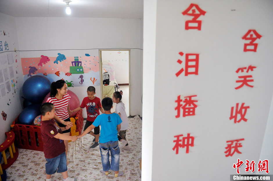 Li XiaoJiao play games with the children with autism. Li established a non-profit classroom special for children with autism 5 years ago in Taiyuan, north China’s Shanxi province. (Photo by Weiliang/ Chinanews.com)