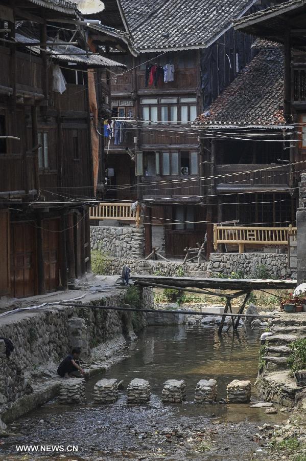 A woman of Dong ethnic group washes clothes near a brook at Zhaoxing Dong Village in Liping County, southwest China's Guizhou Province, June 20, 2013. Zhaoxing Dong Village is one of the largest Dong village in Guizhou. In 2005, it was ranked one of China's six most beautiful villages and towns by Chinese National Geography. (Xinhua/Ou Dongxu) 