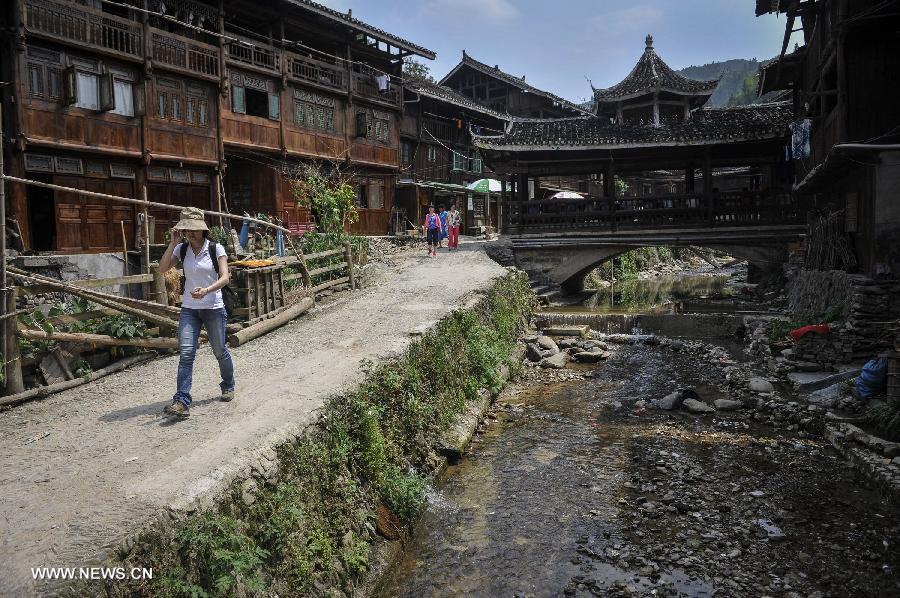 Tourists go sightseeing at Zhaoxing Dong Village in Liping County, southwest China's Guizhou Province, June 20, 2013. Zhaoxing Dong Village is one of the largest Dong village in Guizhou. In 2005, it was ranked one of China's six most beautiful villages and towns by Chinese National Geography. (Xinhua/Ou Dongxu)