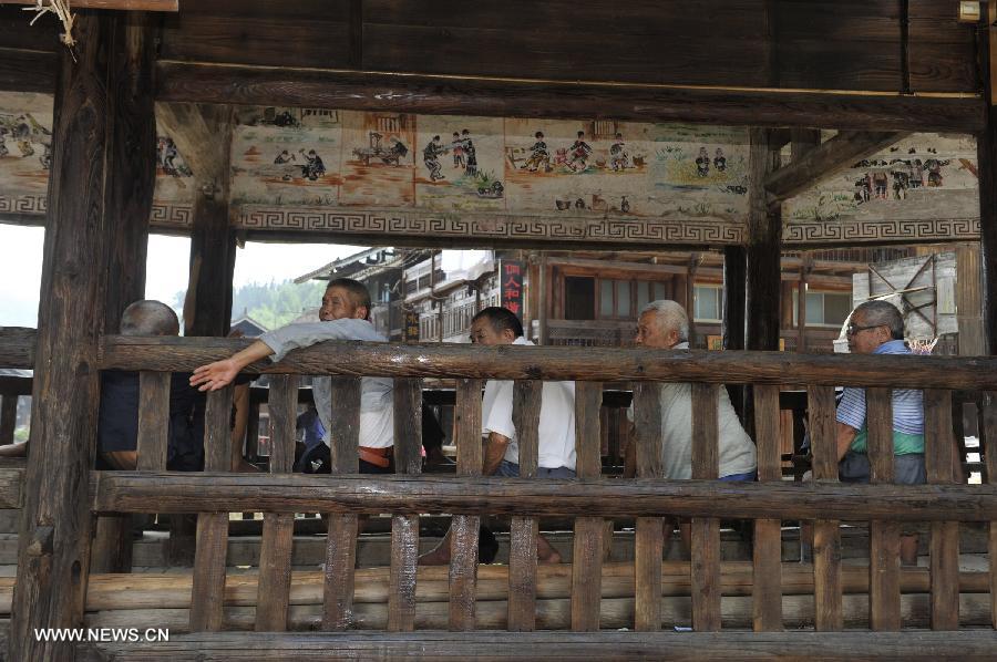 People rest at a wind and rain bridge of Zhaoxing Dong Village in Liping County, southwest China's Guizhou Province, June 20, 2013. Zhaoxing Dong Village is one of the largest Dong village in Guizhou. In 2005, it was ranked one of China's six most beautiful villages and towns by Chinese National Geography. (Xinhua/Ou Dongxu)