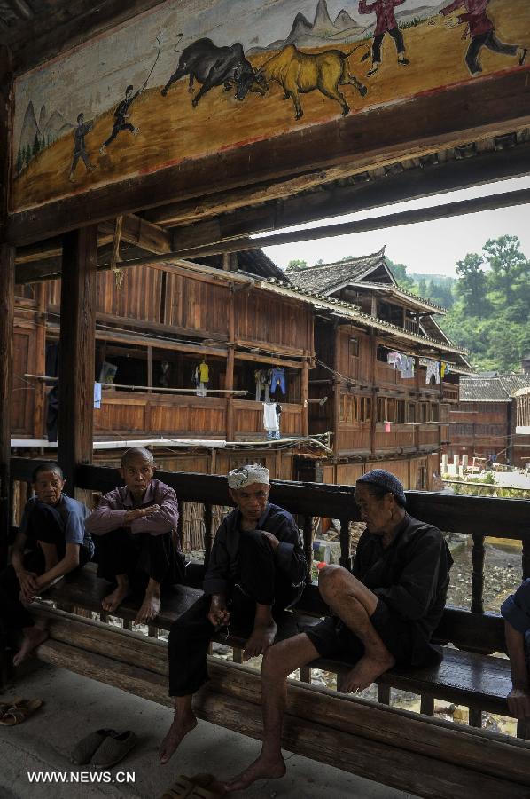 People chat at a bridge of Zhaoxing Dong Village in Liping County, southwest China's Guizhou Province, June 20, 2013. Zhaoxing Dong Village is one of the largest Dong village in Guizhou. In 2005, it was ranked one of China's six most beautiful villages and towns by Chinese National Geography. (Xinhua/Ou Dongxu)