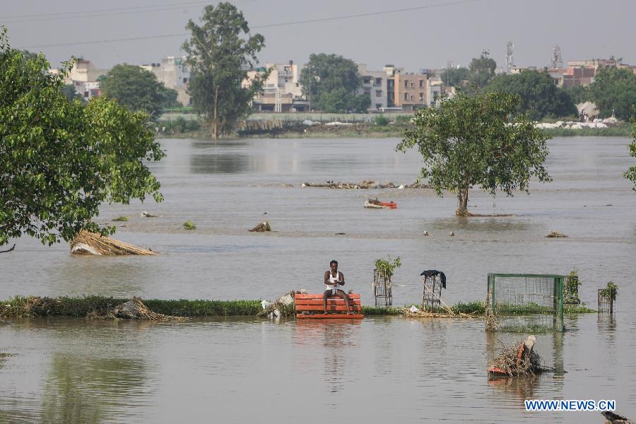 A man sits in a flooded park near the Yamuna River in New Delhi, India, June 20, 2013. The Indian capital has been put on flood alert after its main Yamuna river breached the danger mark following incessant rainfall since June 16. So far, more than 150 people have died in Uttarakhand floods, while thousands have been displaced and stranded, according to reports. (Xinhua/Zheng Huansong) 