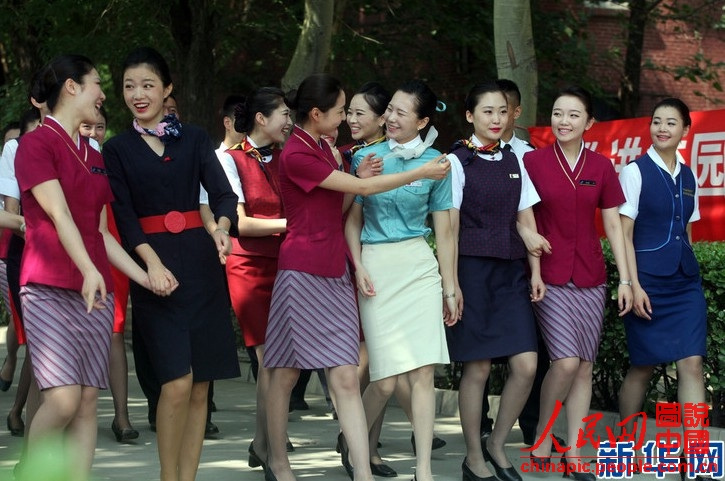 Wearing the uniforms of different airlines, graduates become beautiful landscape at the graduation ceremony on June 19, 2013. (Xinhua/Liu Yuedong)