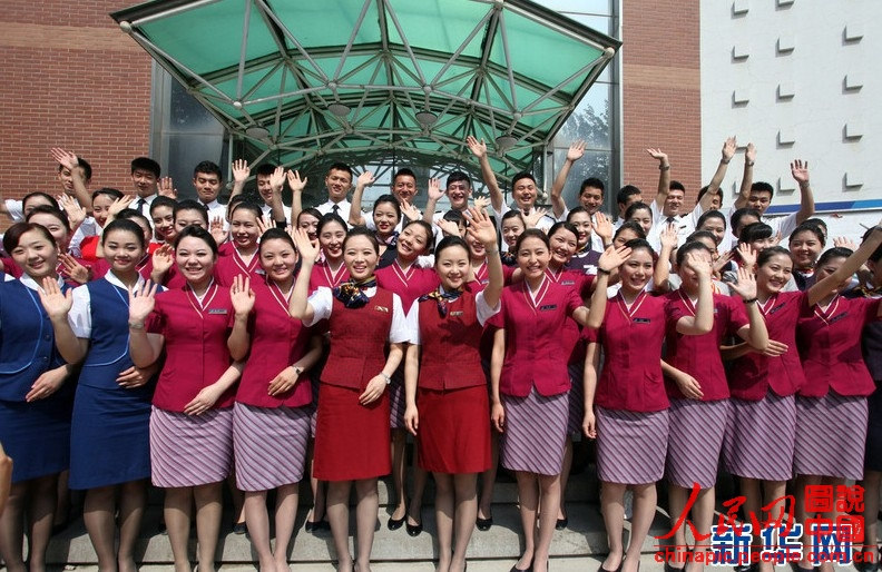 Wearing the uniforms of different airlines, graduates pose for photo on campus on June 19, 2013. (Xinhua/Liu Yuedong)