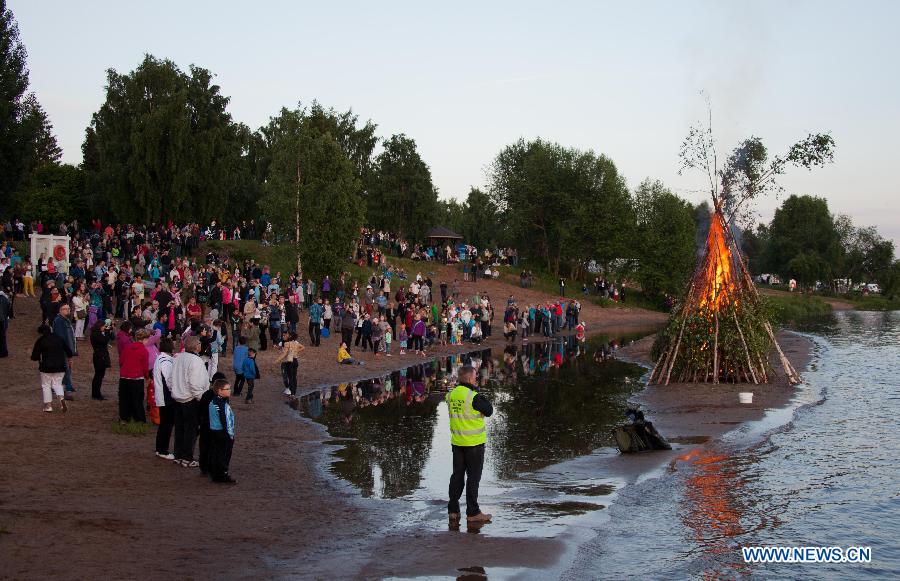People gather around a bonfire to celebrate summer solstice in the Arctic Circle, in June 21, 2013. As Lapland situates in the Arctic Circle, there happens polar day in Summer solstice. Night and day the midnight sun stays above the horizon.(Xinhua/Yan Ting) 