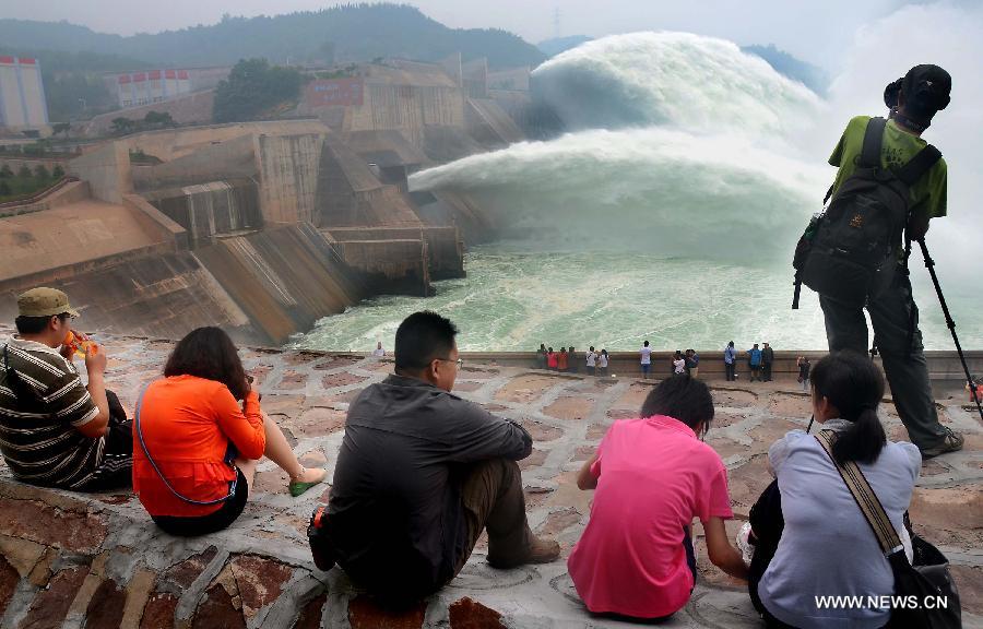 Tourists watch as water gushing out of the Xiaolangdi Reservoir on the Yellow River during a water and sediment regulating operation in Sanmenxia City of central China's Henan Province, June 22, 2013. The water and sediment regulating operation of Xiaolangdi Reservoir is conducted every year to clear out the mud and sand accumulated at the dam. (Xinhua/Wang Song)