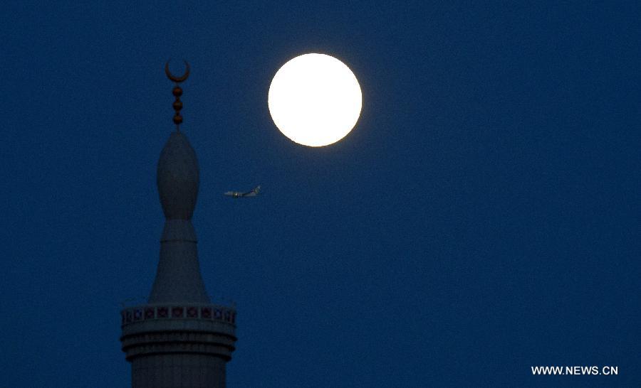 A super moon hangs in the sky over Rotterdam, the Netherlands, on June 22, 2013. On Saturday a perigee moon coincided with a full moon creating a "super moon" when it passed by the earth at its closest point in 2013. (Xinhua/Robin Utrecht) 