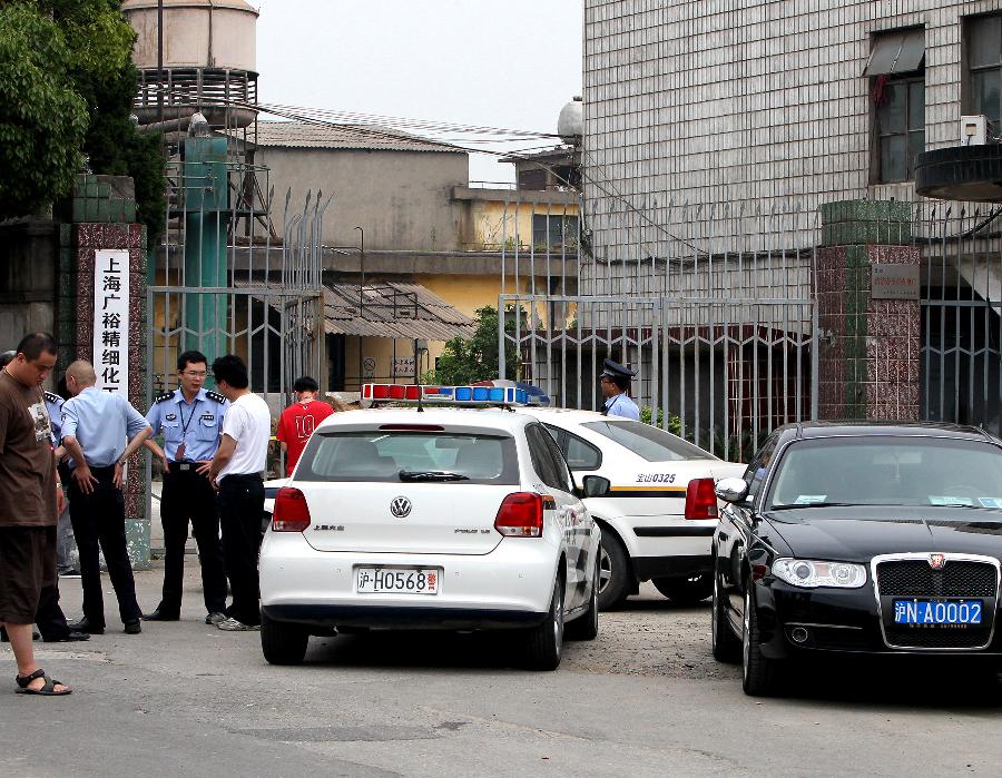 Policemen guard at the murder site at a chemical factory in Baoshan District, east China's Shanghai Municipality, June 23, 2013. Police arrested late Saturday a 62-year-old man, surnamed Fan, who murdered six people, including four colleagues, a driver and a barracks guard in Shanghai. (Xinhua/Chen Fei)