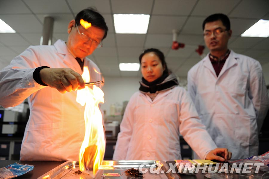 Lyu Changfu (L) burns toilet paper to exam its quality in the laboratory. (Xinhua/ Huang Junhui) 