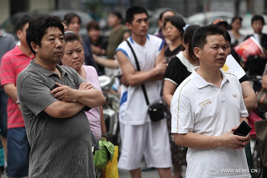 Parents wait for their children taking the 2013 senior high school entrance examination in the No. 31 Middle School in Beijing, capital of China, June 24, 2013. About 88,000 middle school students participated in the three-day examination which lasts from June 24 to June 26 in Beijing. (Xinhua/Jin Liwang)