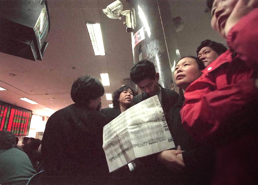Photo shows Beijing investors watch the stock price closely. Stock index of Shanghai and Shenzhen kept rising driven by some tech stocks and SOE large capitalization stocks. SSE Composite index hit a record high of 1,847.51 points and closed at 1,847.03 points on April 20, 2000. (Xinhua/ Song Xiaogang)