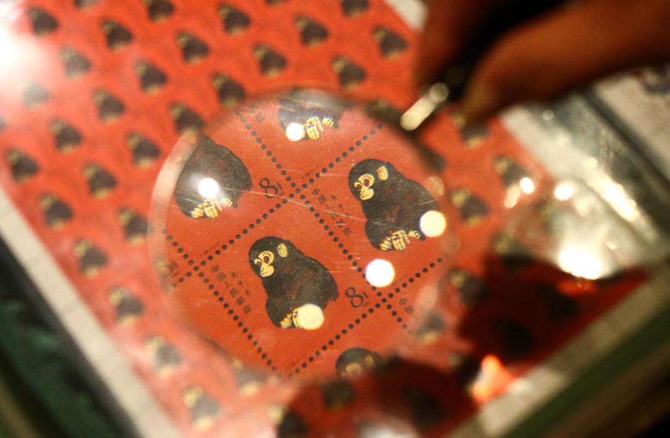 Visitors view the first round of zodiac stamps for the year of the Monkey issued by China Post in 1980 through a magnifier. More than 1,000 kinds of rare stamps were exhibited in Weifang Museum in east China’s Shandong province on June 15, 2013. (Photo by Sun Shubao/ Xinhua)
