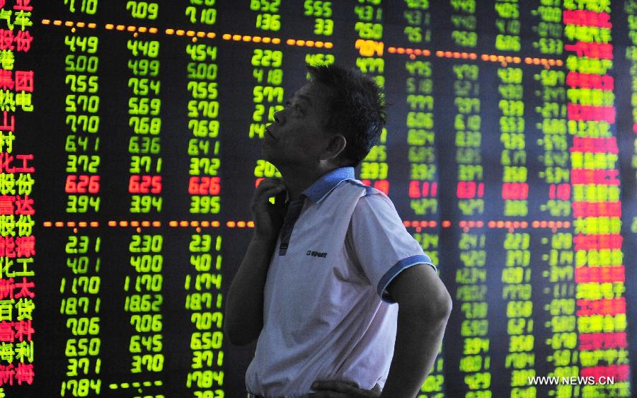 An investor looks at the stock information at a trading hall of a securities firm in Shenyang, capital of northeast China's Liaoning Province, June 25, 2013. Chinese shares extended losses on Tuesday following Monday's drastic slump as the benchmark Shanghai Composite Index lost 0.19 percent, or 3.73 points, to end at 1,959.51, the lowest point in nearly seven months. The Shenzhen Component Index shrank 1.23 percent, or 93.43 points, to 7,495.10. (Xinhua)