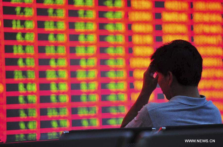 An investor is seen at a trading hall of a securities firm in Luoyang City, central China's Henan Province, June 25, 2013. Chinese shares extended losses on Tuesday following Monday's drastic slump as the benchmark Shanghai Composite Index lost 0.19 percent, or 3.73 points, to end at 1,959.51, the lowest point in nearly seven months. The Shenzhen Component Index shrank 1.23 percent, or 93.43 points, to 7,495.10. (Xinhua/Zhang Yixi) 