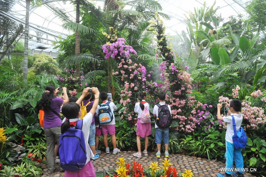 Students from Huiwen No.1 primary school visit a greenhouse in the botanic garden in Beijing, capital of China, June 25, 2013. Students from a biology group of the Huiwen No.1 primary school visited Beijing Botanic Garden Tuesday to enrich their understanding of various plants. (Xinhua/Chen Yehua)  
