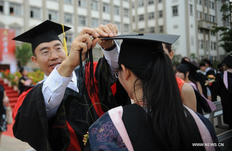 Students and professors take part in the 2013 graduation ceremony in the Business School of Yunnan Normal University in Kunming, capital of southwest China's Yunnan Province, June 25, 2013. Over 3,000 students graduated from the university. (Xinhua/Qin Lang)
