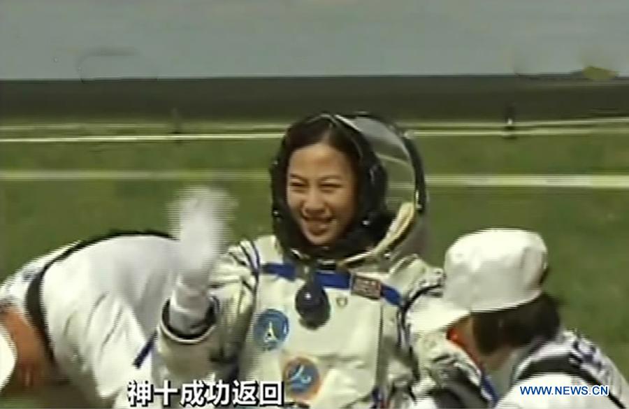 The screenshot shows astronaut Wang Yaping (C) waving to people after going out of the re-entry capsule of China's Shenzhou-10 spacecraft following its successful landing at the main landing site in north China's Inner Mongolia Autonomous Region on June 26, 2013. (Xinhua)