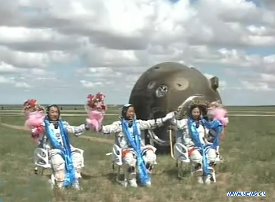 The screenshot shows astronauts Zhang Xiaoguang, Nie Haisheng and Wang Yaping (from left to right) waving to people after going out of the re-entry capsule of China's Shenzhou-10 spacecraft following its successful landing at the main landing site in north China's Inner Mongolia Autonomous Region on June 26, 2013. (Xinhua)