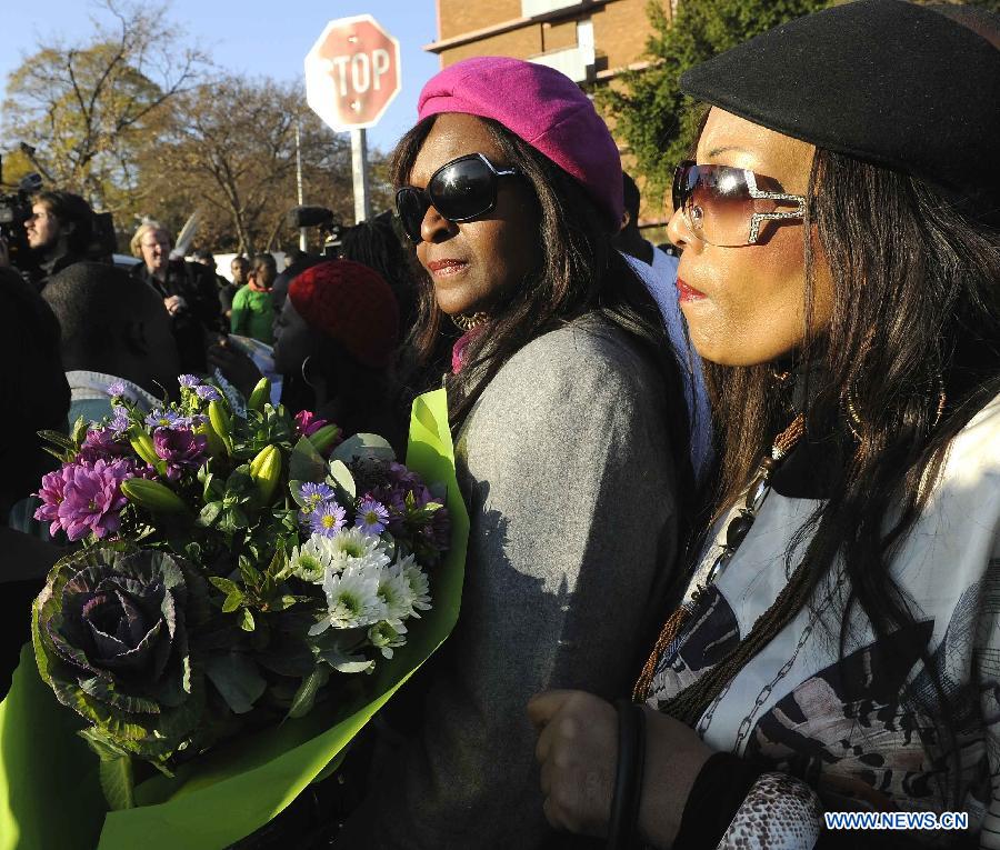 People gather outside the hospital where South Africa's anti-apartheid icon Nelson Mandela is treated in Pretoria, South Africa, to pray for Mandela, June 26, 2013. South Africa's President Zuma said on Wednesday that Mandela's condition "remains in a critical condition in hospital we must keep him and the family in our thoughts and prayers every minute." (Xinhua/Li Qihua) 